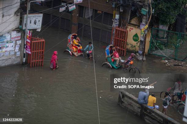 Rickshaws move through a waterlogged Dhaka street following heavy rains causing much suffering for pedestrians and commuters. Cyclone Sitrang hits...