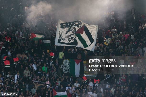 Paris Saint-Germain supporters hold Palestinian flags during the UEFA Champions League Group H second leg football match between Paris Saint-Germain...