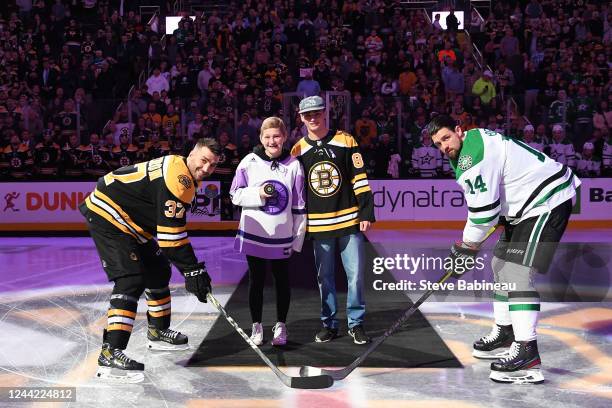 Mya White whos cancer is in remission drops the puck before the game with Patrice Bergeron of the Boston Bruins and Jamie Benn of the Dallas Stars at...