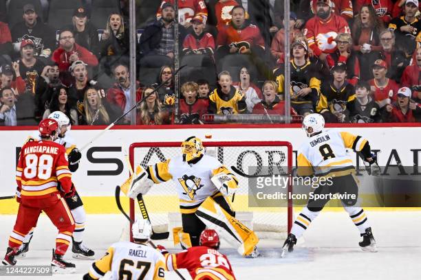 Fans watch the puck land on top of the net behind Pittsburgh Penguins Goalie Casey DeSmith during the first period of an NHL game between the Calgary...