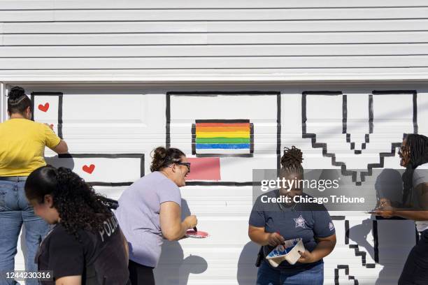 Megan Mathias, third from left, laughs with Chicago police officers Calla Roulds and Patrise Washington, right, while they help Erica Hungerford and...