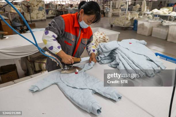 Worker produces children's clothing, which will be exported, at a textile factory in Binzhou in China's eastern Shandong province on October 26,...