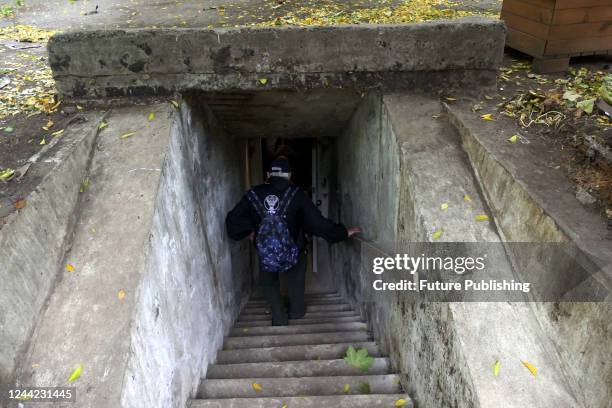 Senior man goes down the stairs into an air raid shelter set up by volunteers in an old shelter built after WWII in Shevchenko Park, Odesa, southern...
