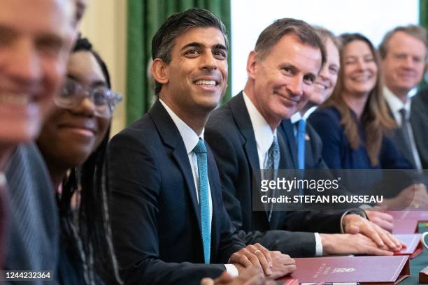 Britain's Prime Minister Rishi Sunak poses for a photograph alongside Britain's Chancellor of the Exchequer Jeremy Hunt and Britain's Secretary of...