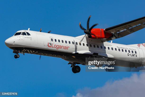 Loganair ATR 72 turboprop aircraft as seen on final approach flying over the houses of Myrtle avenue in London, a famous location for plane spotting,...