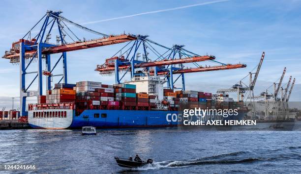 Small boats pass in front of the container ship 'Xin Lian Yun Gang' of China COSCO Shipping Corporation as it is unloaded at the Tollerort Container...