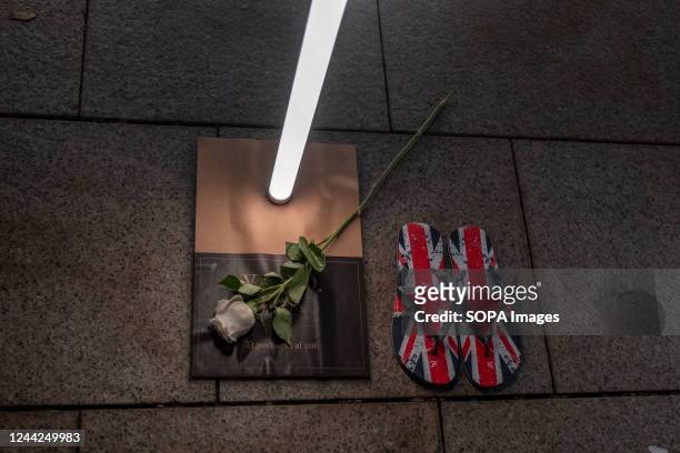 White rose and British flag slippers accompanied with the name of a homeless person who died in 2022. The social entity Fundación Arrels has called...