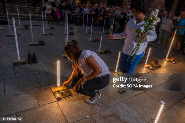 Two people are seen laying white roses on the names of homeless people who died during 2022, some of them on the streets. The social entity Fundación...