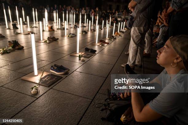 Crowd of people look at the lights, shoes and white roses of the homeless people who died during 2022, some of them on the streets. The social entity...