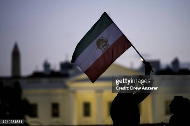 Man holds up an Iranian flag during a vigil in support of protestors in Iran and to mark 40 days since the death in Iran of Masha Amini, in Lafayette...