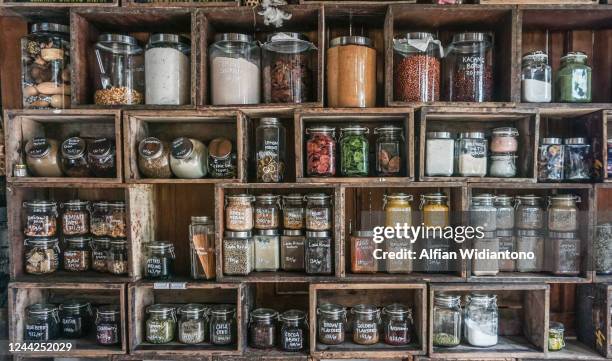 jars containing spices and herbs in diy wooden rack - spice market stock pictures, royalty-free photos & images