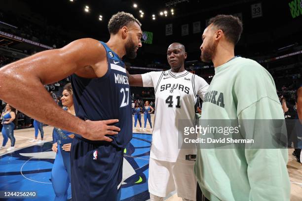 Rudy Gobert and Kyle Anderson of the Minnesota Timberwolves talk to Gorgui Dieng of the San Antonio Spurson October 26, 2022 at Target Center in...