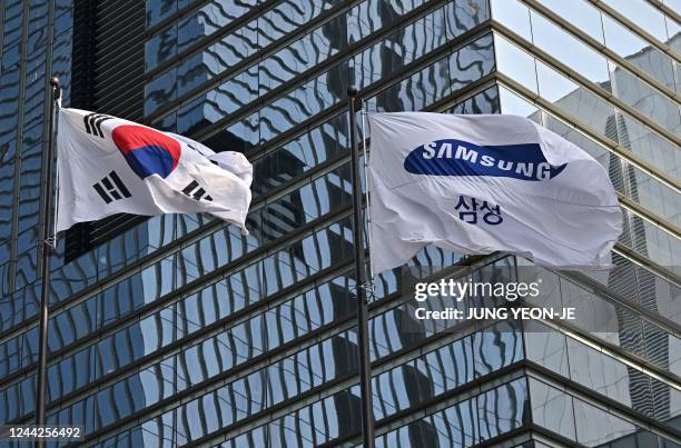 South Korean naitonal flag and a Samsung flag flutter outside the company's Seocho building in Seoul on October 27, 2022. - South Korean tech giant...