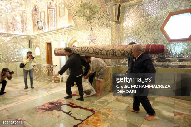 Workers clean up the scene following an armed attack at the Shah Cheragh mausoleum in the Iranian city of Shiraz on October 26, 2022. - At least 15...