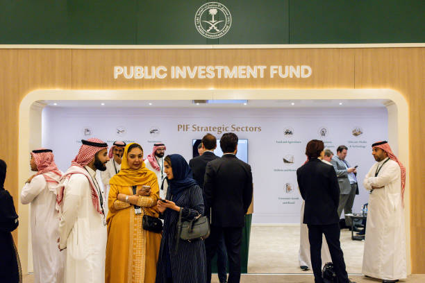 Attendees visit the Public Investment Fund booth on day two of the Future Investment Initiative conference in Riyadh, Saudi Arabia, on Wednesday,...