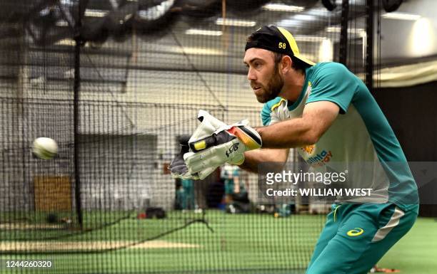 Australian player Glenn Maxwell practices with wicketkeeper gloves in the nets during a training session in Melbourne on October 27 ahead of their...