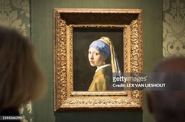 Visitors looks at the Johannes Vermeer's painting "Girl with a Pearl Earring" at the Mauritshuis museum in The Hague, 27 October 2022. - Dutch police...