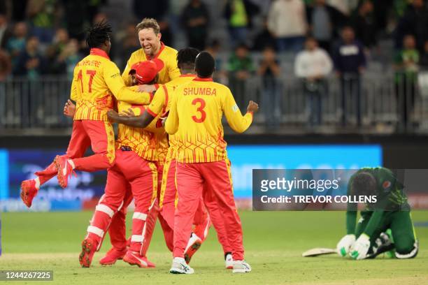 Zimbabwe's players celebrate their victory as Pakistan's Mohammad Wasim reacts at the end of the ICC mens Twenty20 World Cup 2022 cricket match...