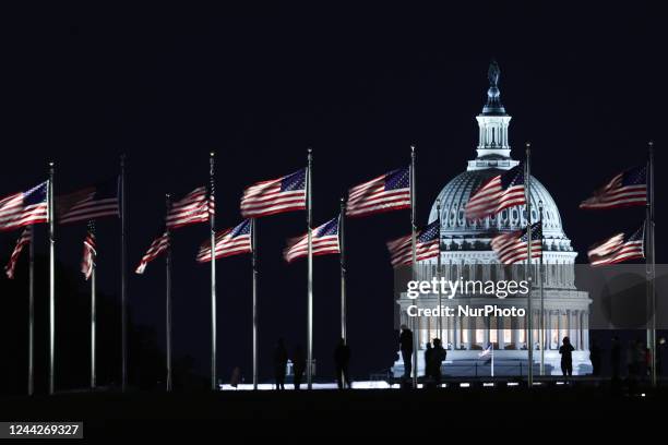 The Capitol building is seen through the American flags in Washington DC on October 20, 2022.