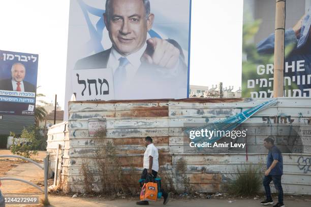 Women walk by a 'Likud' and Yisrael Beitenu' parties campaign posters showing former Prime Minister, Benjamin Netanyahu and Avigdor Liberman on...