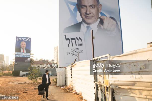 Man walks by a 'Likud' and Yisrael Beitenu' parties campaign posters showing former Prime Minister, Benjamin Netanyahu and Avigdor Liberman on...