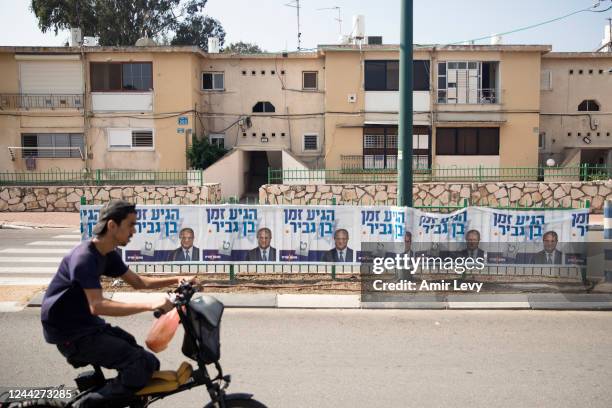 Man rides by a 'Jewish Zionist' party campaign poster showing party member Itamar Ben Gvir on October 27, 2022 in Or Akiva, Israel. Israelis return...