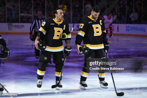 Brad Marchand and Patrice Bergeron of the Boston Bruins stand during the national anthem before the game against the Detroit Red Wings at the TD...