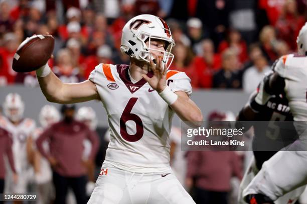 Grant Wells of the Virginia Tech Hokies drops back to pass against the North Carolina State Wolfpack during the first half at Carter-Finley Stadium...