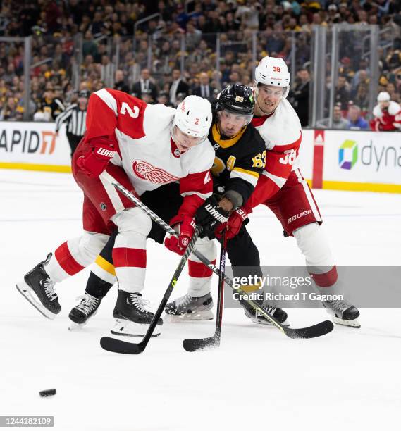 Olli Maatta of the Detroit Red Wings and teammate Robert Hagg check Brad Marchand of the Boston Bruins during the third period at the TD Garden on...