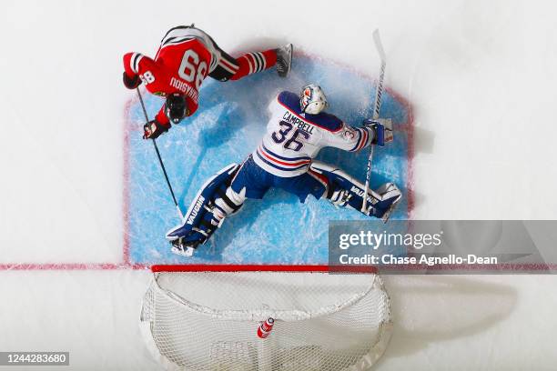 Jack Campbell of the Edmonton Oilers makes a save against Andreas Athanasiou of the Chicago Blackhawks in the first period at the United Center on...