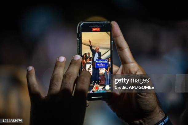 Man takes video with his phone as US Sen. Bernie Sanders speaks during a campaign rally for Los Angeles Democratic mayoral candidate Rep. Karen Bass...