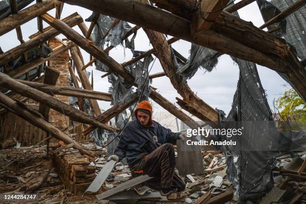 Worker collects wood and roofing materials in a destroyed home in the recently retaken village of Velyka Oleksandrivka in Kherson, Ukraine on October...