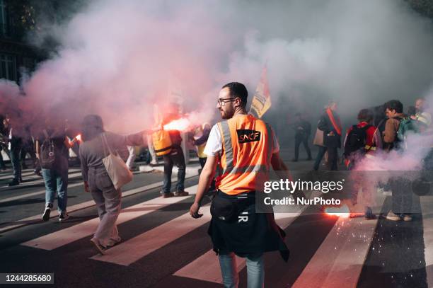 Striking railway workers from the SNCF centre in Versailles hold up red flares during a demonstration in which several hundred people took part,...