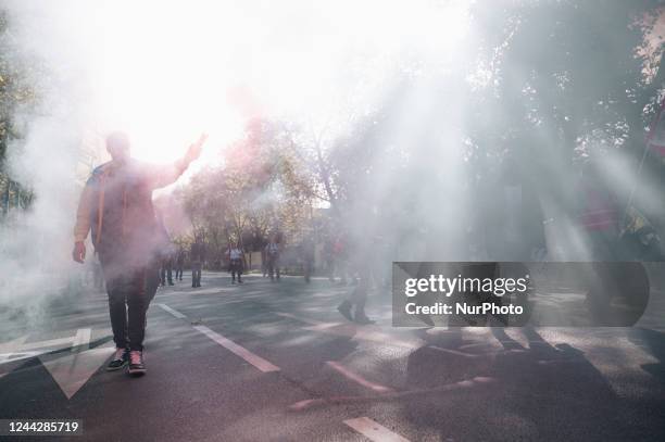 Striking railway workers from the SNCF hub in Versailles walk amid smoke from red flares during a demonstration attended by several hundred people,...