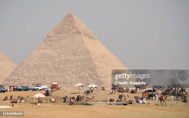 People and camels are seen near the Great Pyramid of Giza, the Pyramid of Khafre, and the Pyramid of Menkaure in Cairo, Egypt on October 27, 2022.