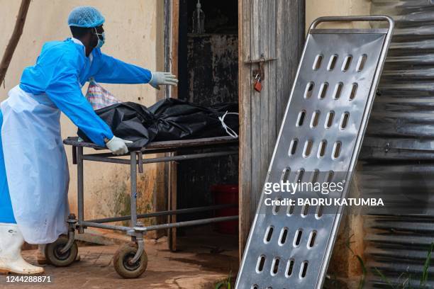 Photo taken on October 27 shows workers at Mubende referral hospital moving a body bag containing the body of a man suspected of dying from Ebola in...