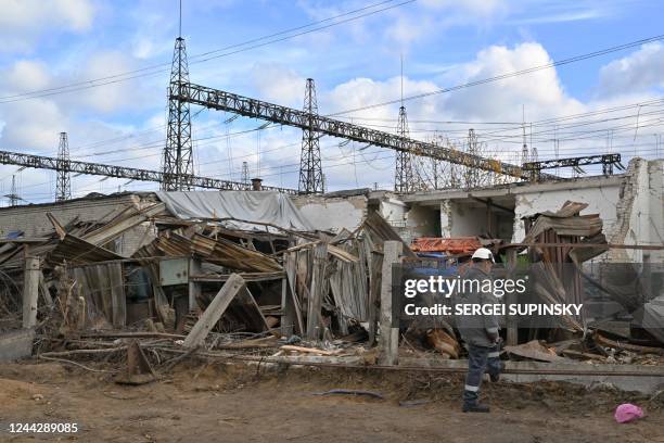 Worker examines destructions as he repairs equipments of power lines destroyed after a missile strike on a power plant, in an undisclosed location of...