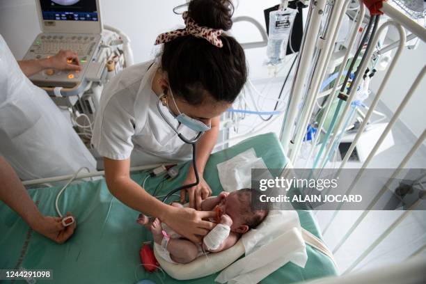 Pediatric doctor tend to a baby hospitalized at the pediatric intensive care unit at the Robert Debre hospital in Paris on October 28, 2022. / The...