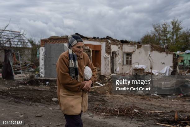 Woman carries food from a charity kitchen after her home was heavily damaged by a Russian missile attack, on October 28, 2022 in Zaporizhzhia,...