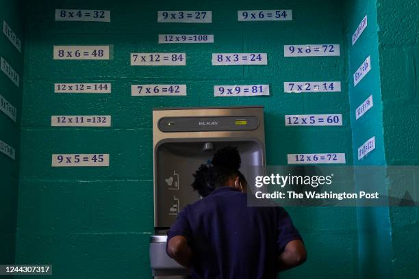 Student sips water under a wall of multiplication equations at the Center City Public Charter School - Congress Heights on October 14 in Washington,...