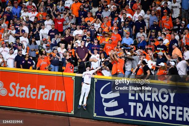 Kyle Tucker of the Houston Astros is unable to catch a home run ball from J.T. Realmuto of the Philadelphia Phillies in the tenth inning during Game...