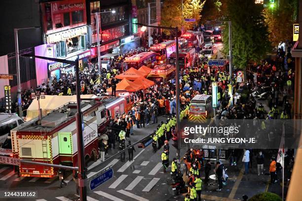 Crowds are seen around the area, where dozens of people suffered cardiac arrest, in the popular nightlife district of Itaewon in Seoul on October 30,...