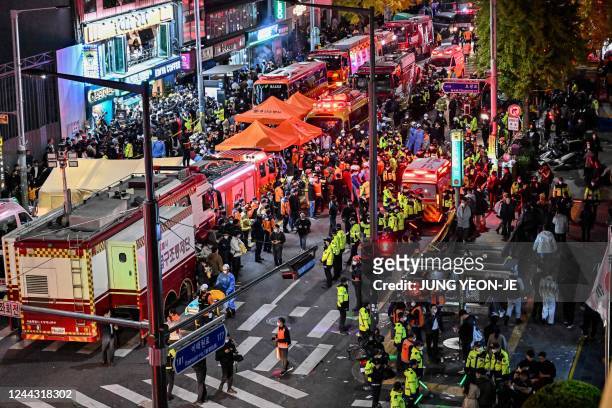 Onlookers, police and paramedics gather where dozens of people suffered cardiac arrest, in the popular nightlife district of Itaewon in Seoul on...
