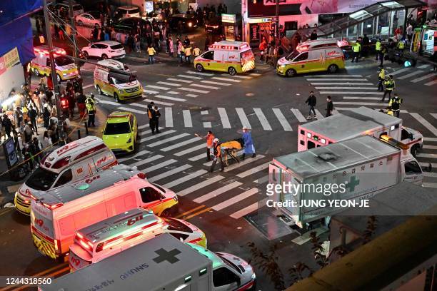 Person, believed to have suffered cardiac arrest, is transported in a stretcher in the popular nightlife district of Itaewon in Seoul on October 30,...