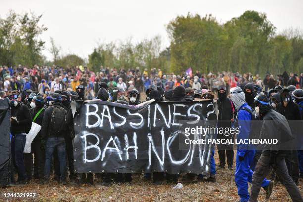 Activists hold a banner reading "Basins, well no" during a demonstration called by the collective "Bassines Non Merci" against the "basins" near the...
