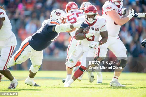 Running back Raheim Sanders of the Arkansas Razorbacks looks to escape a tackle by defensive end Colby Wooden of the Auburn Tigers during the second...
