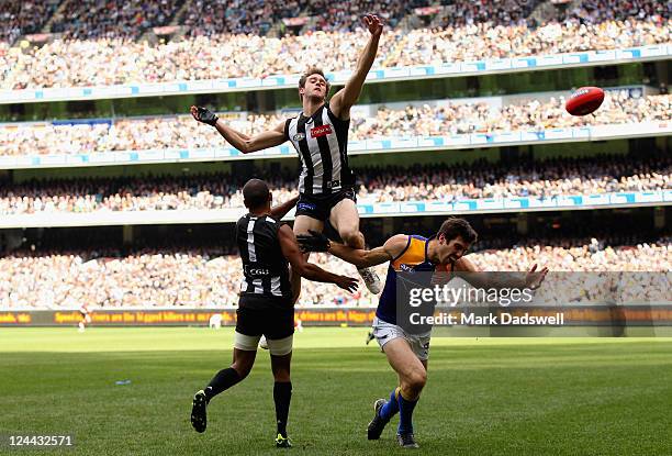 Alan Toovey of the Magpies punches the ball clear of Quinten Lynch of the Eagles during the AFL First Qualifying match between the Collingwood...