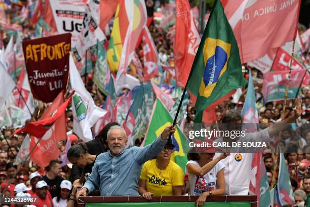 Brazilian former President and candidate for the leftist Workers Party Luiz Inacio Lula da Silva waves a national flag next to his wife Rosangela and...