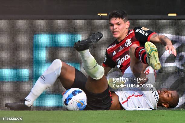 Flamengo's Brazilian defender Ayrton Lucas and Athletico Paranaense's Brazilian midfielder Fernandinho vie for the ball from the ground during the...