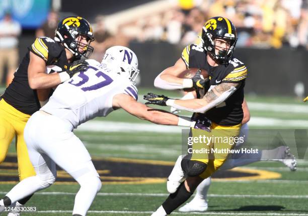 Wide receiver Brody Brecht of the Iowa Hawkeyes goes up the field during the first half against linebacker Greyson Metz of the Northwestern Wildcats...